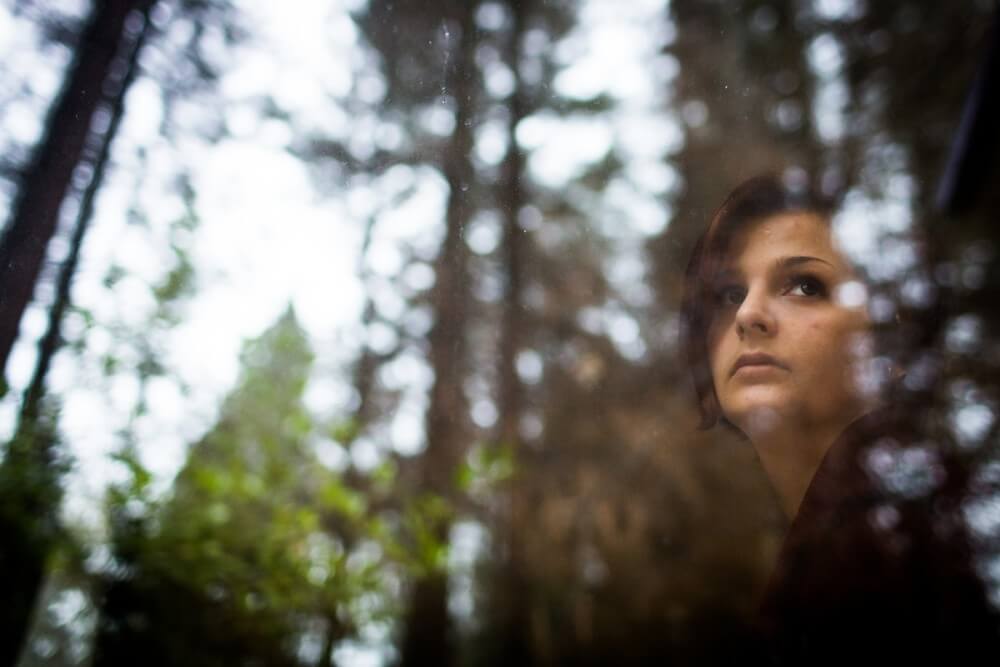 Portrait of Allyson Bendell with the forest reflecting in the background