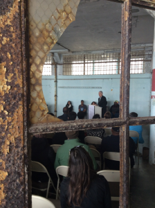 George Gascon receiving an award for his commitment to restorative justice, seen through a broken window in the New Industries Building on Alcatraz. Credit: Jack Bennett