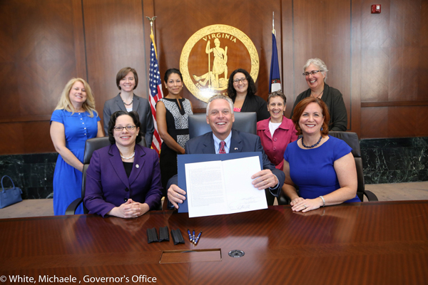 Virginia Governor Terry McAuliffe, (center) signs into law a bill establishing 16 as the minimum age for marriage. He is flanked by Virgina Delegate Jennifer McClellan (front left), and Jeanne Smoot of Tahirih Justice Center. Photo: Virginia Governor's office.