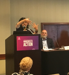 Joyce Dorado addresses a session on educational interventions at the conference as Chris Blodgett look on.