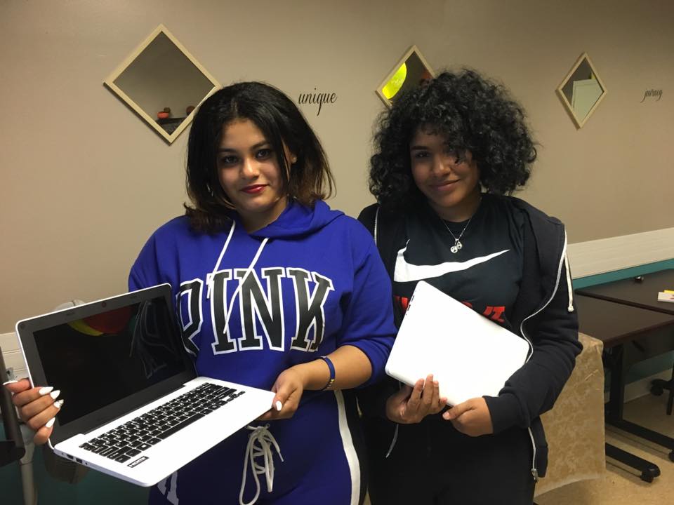 Foster youth who holding new laptops they received from iFoster