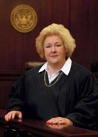 A photo of U.S. District Court Judge Janis Graham Jack in her robe with a state seal behind her.
